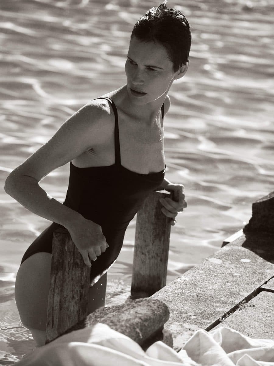 Black and white shot of a woman in an Asceno swimsuit by the sea